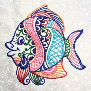 May include: A colorful embroidered fish design with intricate details in shades of pink, blue, green, and orange. The fish has a large, round body and a small, pointed tail.
