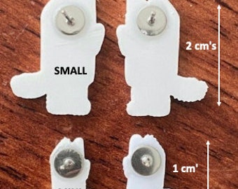 May include: Three white enamel pins in the shape of a cat. The pins are different sizes: small, mini, and extra small. The pins have a silver post and butterfly clutch on the back. The pins are 2-2.5 cm, 1-1.5 cm, and 1 cm in size.