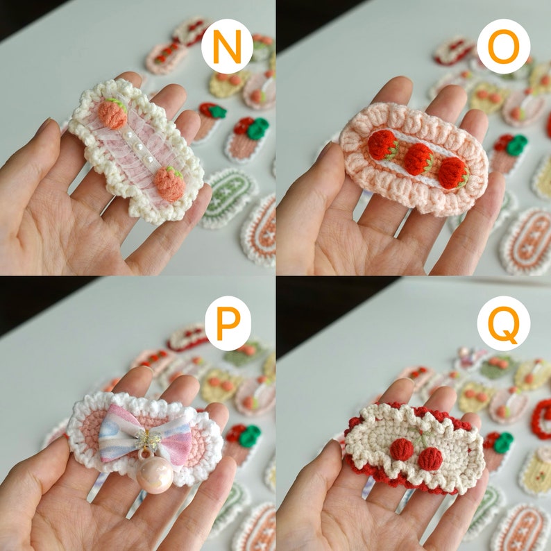May include: A collection of handmade crochet hair clips in various designs. The clips feature strawberry, bow, and cherry motifs, with a mix of pink, white, and red colors. The clips are oval and rectangular shaped.