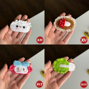 Op de afbeelding: Vier handgemaakte gehaakte applicaties worden getoond. Ze omvatten een wit schaap, een paddenstoel met een rode dop, een roze karakter met een blauwe strik en een groene en witte groente. Elke applicatie wordt in een hand gehouden.