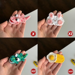 Op de afbeelding: Vier handgemaakte gehaakte haarclips. De clips bevatten een roze hagedis, een witte konijn met roze accenten, een groene alligator en een gebakken ei. Elke clip is een uniek, grillig ontwerp.