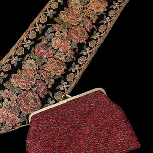May include: A red beaded clutch purse with a gold clasp. The purse has a geometric pattern and is made of small, shiny beads.