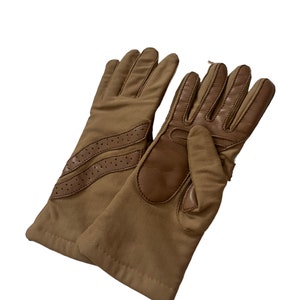 May include: A pair of brown leather driving gloves with a tan fabric back. The gloves have a perforated leather detail on the back of the hand.