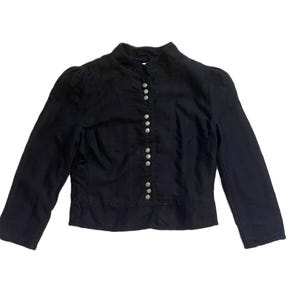May include: A black jacket with a high collar and long sleeves. The jacket has silver-coloured buttons down the front and a fitted silhouette. The fabric appears to be a medium-weight material, suitable for cooler weather. The jacket has a classic, tailored design.