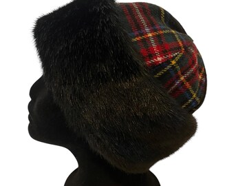 May include: A black fur hat with a plaid pattern in red, green, blue, and yellow. The hat is on a black mannequin head.