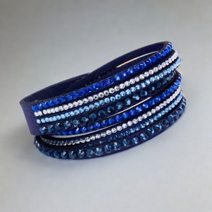 May include: A blue leather wrap bracelet with multiple rows of blue and clear crystal rhinestones.