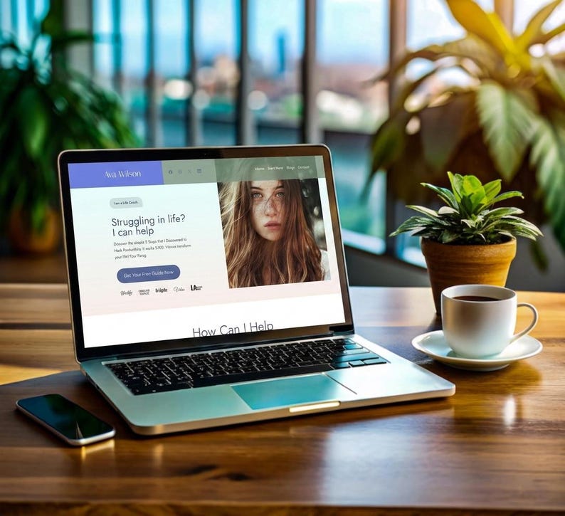 May include: A silver laptop displaying a website with the text Ava Wilson, Struggling in life? I can help, and Get Your Free Guide Now, alongside a portrait of a person. A smartphone, a white coffee cup on a saucer, and a small potted plant are nearby.