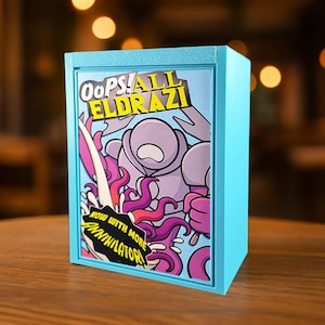 Puede incluir: Caja azul claro con una ilustración de dibujos animados. La obra presenta una criatura morada con tentáculos y el texto "Oops! All Eldrazi" y "Now with More Annihilator" sobre un fondo blanco.