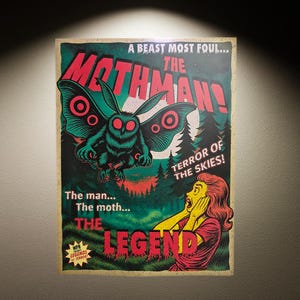 Może przedstawiać: Plakat w stylu vintage z ilustracją Mothmana w kolorze turkusowym, czerwonymi oczami i skrzydłami, na tle lasu. Tekst zawiera "THE MOTHMAN!" i "TERROR OF THE SKIES!". Z postarzałym wyglądem.