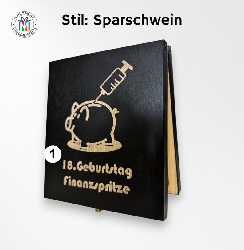 May include: Black wooden piggy bank with a laser-etched design. The design features a pig with a syringe, and the text "18. Geburtstag finanzspritze". The bank is a personalized gift.