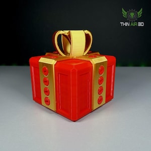 Puede incluir: Una caja de regalo roja con un lazo dorado y detalles dorados. La caja está decorada con círculos dorados.