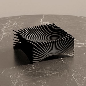 Könnte beinhalten: Ein moderner, schwarzer Stuhl mit einem einzigartigen Design. Der Stuhl besteht aus zahlreichen gebogenen, parallelen Lamellen, die eine wellenartige Form bilden. Er steht vor einem neutralen Hintergrund.