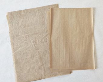 May include: Two rectangular sheets of light brown paper. One sheet on the left has a wrinkled, textured surface, while the sheet on the right is smooth and flat. Both pieces of paper are thin, translucent, and have a natural tan color.