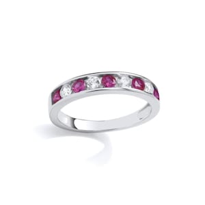 May include: A white gold band ring with alternating ruby and diamond stones.
