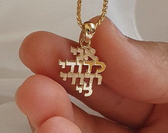Puede incluir: Un collar de cadena de oro con un colgante en forma de corazón con las palabras hebreas "Chai" y "Mazel Tov".