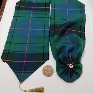 May include: A green, blue and black plaid sash with a gold tassel and a matching plaid bow. The sash is labelled "Davidson clan Ancient tartan".