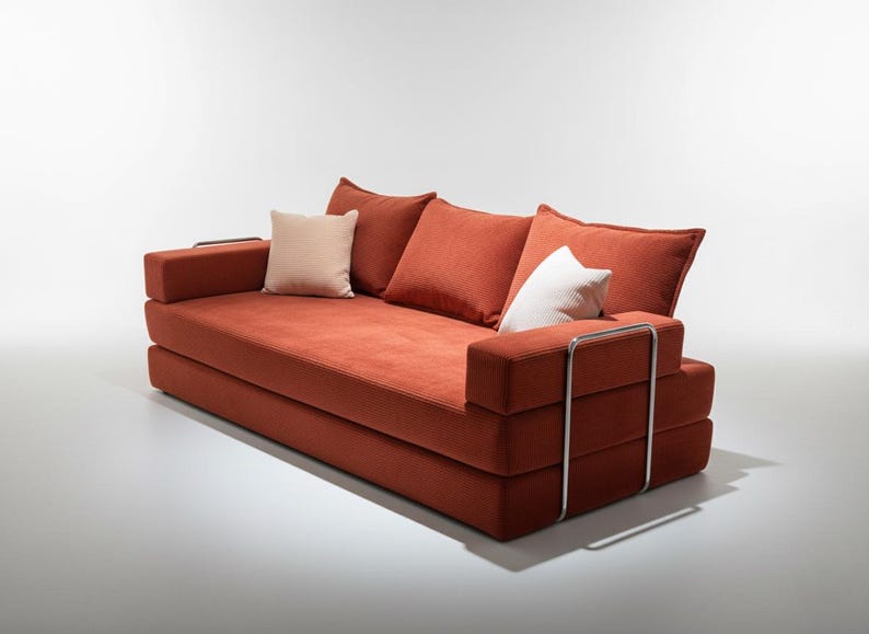May include: A modern, low-profile sofa in a warm orange hue. It features a rectangular design with a series of stacked cushions and armrests. The sofa includes three back cushions and two smaller accent pillows. Polished metal accents add a touch of elegance.