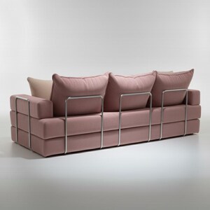 May include: A modern, three-cushion sofa in a soft pink fabric. The sofa features a stacked block design with a stainless steel frame. The cushions are plush and inviting, with a neutral-toned pillow in the back. A stylish piece for any living space.