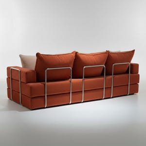 May include: A modern, three-cushion sofa in a burnt orange fabric. The sofa features a rectangular design with a stacked base and back, supported by a polished metal frame. The back cushions are large and plush, with a neutral-colored pillow.