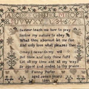 May include: Aged sampler with cross-stitch embroidery, displaying the alphabet, numbers, and a poem. The text includes the name "Fanny Porter" and the year "1841". The border has floral and geometric designs, on a cream-coloured background.