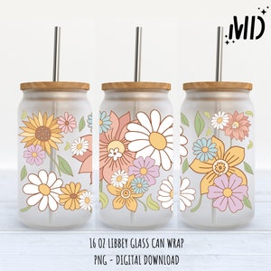 May include: Three 16 oz glass can wraps featuring a floral design. The design includes daisies, sunflowers, and other flowers in shades of pink, yellow, and blue. The wraps are designed to fit a standard 16 oz glass can.