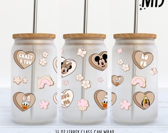 May include: Three 16 ounce glass can wraps with a light brown background and pink and white accents. The wraps feature a variety of Disney characters including Mickey Mouse, Minnie Mouse, Donald Duck, and Goofy. The text on the wraps reads "Crazy & You", "Hug Me", and "Love".