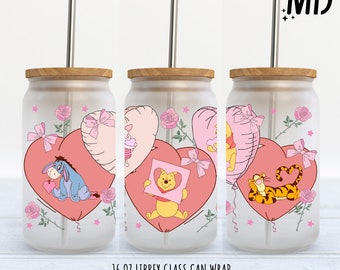 Può includere: Un involucro per lattina in vetro smerigliato con palloncini a forma di cuore e dettagli floreali. Il design include illustrazioni dei personaggi di Winnie the Pooh. La lattina ha un coperchio in bambù e una cannuccia in acciaio inossidabile. Il testo in basso recita "16 OZ LIBBEY GLASS CAN WRAP PNG - DIGITAL DOWNLOAD."