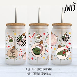 May include: A frosted glass can wrap with a wooden lid and a stainless steel straw. The design features Grinch-themed ornaments with the text "I just took a DNA test turns out I'm 100% that Grinch!" and "Ho Ho Ho".