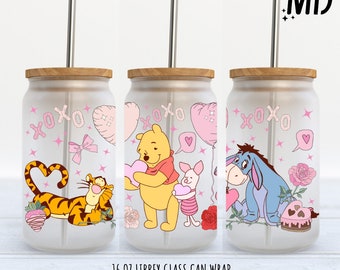 Può includere: Avvolgimento per lattina in vetro smerigliato con personaggi di Winnie the Pooh con grafica a tema San Valentino. Il design include Tigro, Pooh, Pimpi ed Eeyore, con cuori, rose e la scritta "XOXO". Include un coperchio in bambù e una cannuccia in acciaio inossidabile.