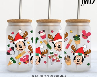 May include: Three 16 ounce clear glass can wraps with a Christmas theme featuring Mickey Mouse wearing a Santa hat and reindeer antlers. The wraps feature a variety of Christmas designs including a Christmas tree, a cupcake, a candy cane, and a Mickey Mouse head with a bow.