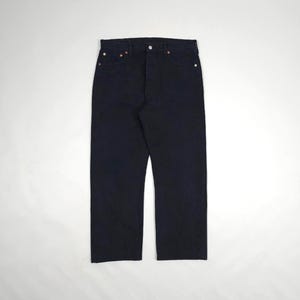 May include: Dark navy blue denim jeans. The jeans have a classic five-pocket design with a button and zip closure. The jeans are straight-legged and appear to be made of a durable denim material. The jeans are displayed on a white background.