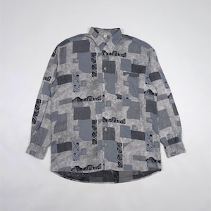 May include: A long-sleeved button-down shirt with a geometric pattern in shades of gray. The shirt features a collared neckline, a chest pocket, and a buttoned cuff. The pattern includes squares and rectangles.