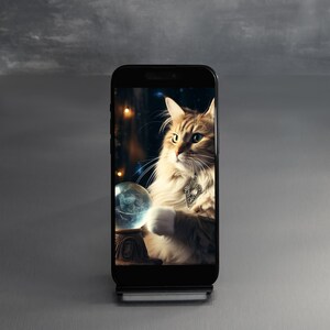 Pode incluir: Um smartphone preto com uma tela mostrando um gato olhando para dentro de uma bola de cristal. O gato está usando um colar de prata com um pingente.