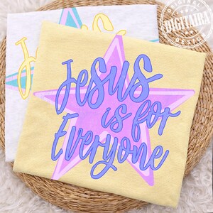 May include: Two t-shirts, one light yellow and one white, are displayed. The yellow shirt features a purple star with the words "Jesus is for Everyone" in blue script. The white shirt has a similar design with the word "Jesus" in yellow.