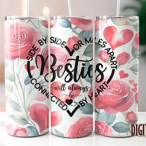 May include: Three stainless steel tumblers with a white background and pink watercolour roses. The tumblers have a black graphic that reads "Side by Side or Miles Apart, Besties - Will Always Be Connected by Heart".