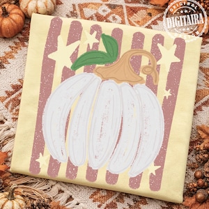 May include: A square throw pillow cover featuring a white pumpkin graphic with a tan stem and green leaves. The background displays vertical dusty rose stripes and pale yellow stars. The text "ORIGINAL DIGITAIRA DESIGN" is in the corner.