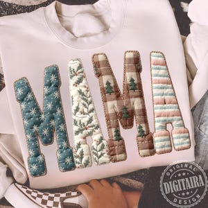 May include: Cream-coloured sweatshirt featuring the word "MAMA" in large, quilted letters. The "M" is teal with white snowflakes, the first "A" has a floral pattern, the second "M" is brown plaid with green trees, and the last "A" is pink and blue striped.