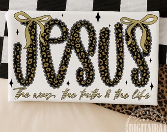 Puede incluir: Cojín rectangular blanco con la palabra "JESUS" en estampado de leopardo con lazos dorados. El texto "The way, the truth & the life" está debajo. Diamantes negros están dispersos alrededor del texto.