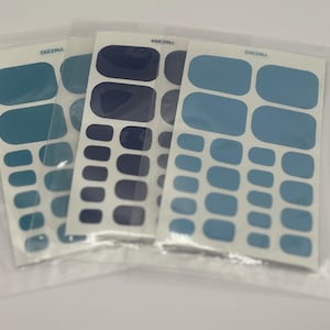 May include: Three sheets of nail stickers in a clear plastic bag. The stickers are in shades of blue and dark blue. The stickers are in different sizes and shapes.