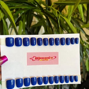 May include: A set of 20 blue press-on nails, arranged in two rows on a white card with the text "BUDGET nails".