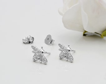 May include: A pair of silver bee stud earrings with clear cubic zirconia stones.