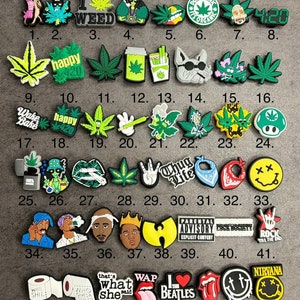 May include: A set of 49 colourful shoe charms featuring various designs, including marijuana leaves, cartoon characters, and popular phrases like "Wake Bake", "Thug Life", and "I Love The Beatles".
