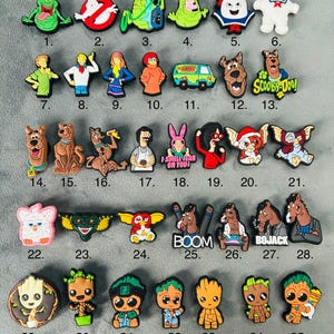 May include: A set of 35 colourful cartoon character shoe charms. The charms feature characters from popular cartoons such as Scooby-Doo, Ghostbusters, and the Grinch. The charms are made of a durable plastic material and are perfect for adding a touch of fun to your shoes.