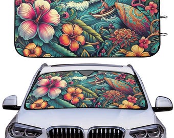 Op de afbeelding: Auto zonnescherm met een levendig tropisch ontwerp. Het kunstwerk bevat grote roze en oranje hibiscusbloemen, groene bladeren en een surfscène met een surfboard. Het zonnescherm wordt getoond op de voorruit van een witte auto.