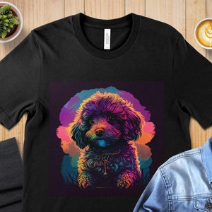 May include: A black t-shirt with a colorful illustration of a small dog with a rainbow-colored fur. The dog is wearing a collar and is looking at the viewer.