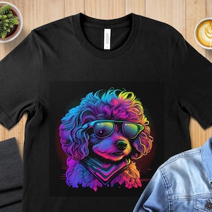 May include: A black t-shirt with a colorful graphic of a poodle wearing sunglasses. The poodle's fur is a mix of pink, blue, and purple.