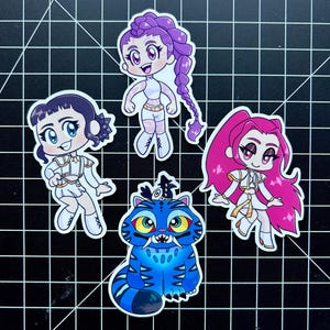 May include: Four colorful stickers featuring anime-style characters. The stickers include three female figures with different hairstyles and outfits, and a blue tiger-like creature with yellow eyes and sharp teeth. The stickers are on a black grid background.