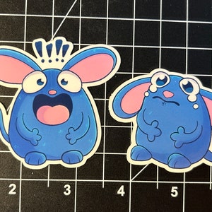 May include: Two blue cartoon mouse stickers. One mouse is surprised with its mouth open and a crown on its head. The other mouse is sad with tears coming from its eyes.