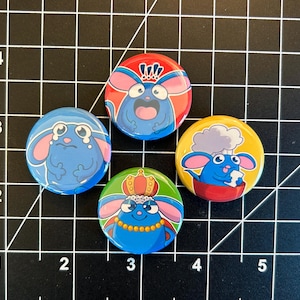 May include: Four round pinback buttons featuring cartoon mice with different expressions and accessories. The buttons are blue, red, yellow, and green with white accents.