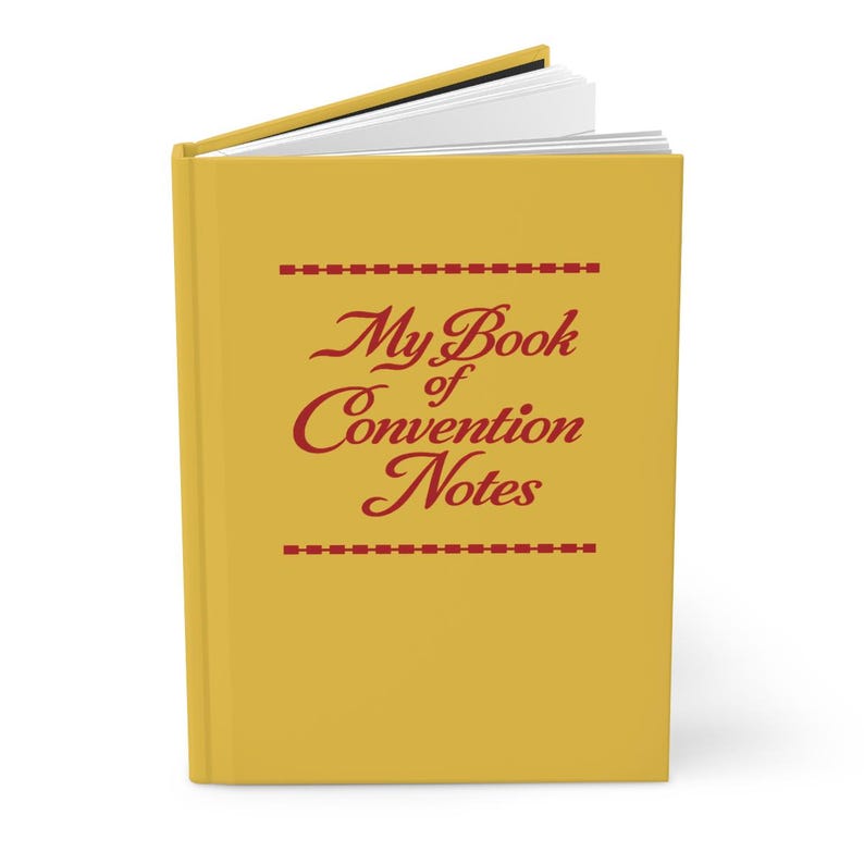 Może przedstawiać: Ż&oacute;łty notatnik z napisem "My Book of Convention Notes" w czerwonym kolorze. Notatnik jest otwarty, ukazując białe strony. Okładka ma czerwone kreski nad i pod tekstem.